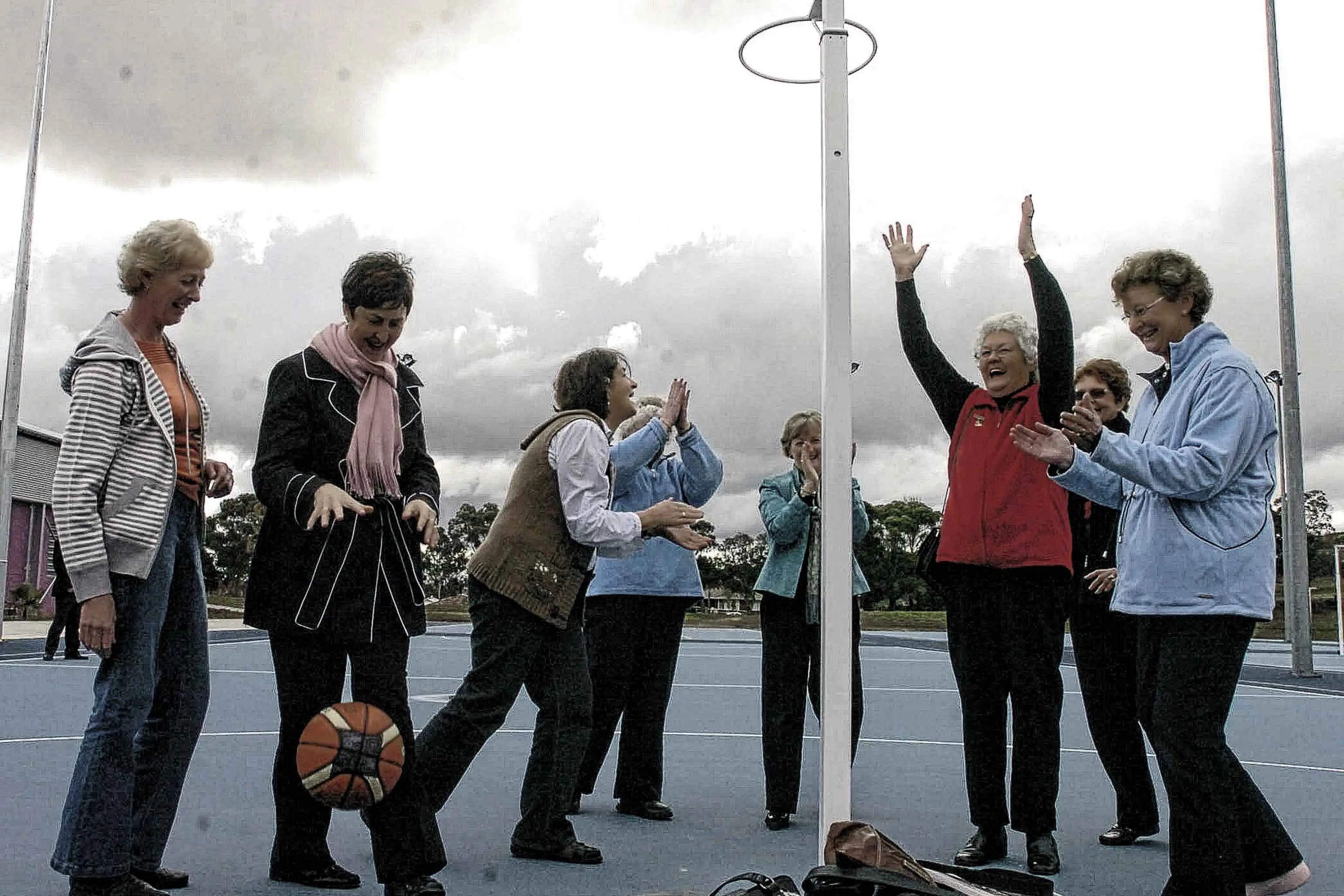 <p>Six former Orange Netball Association presidents, plus a past executive, celebrate the opening of Anzac Park netball courts in 2009. Founder Norma Corse is pictured on the right with hands up.</p>\\n