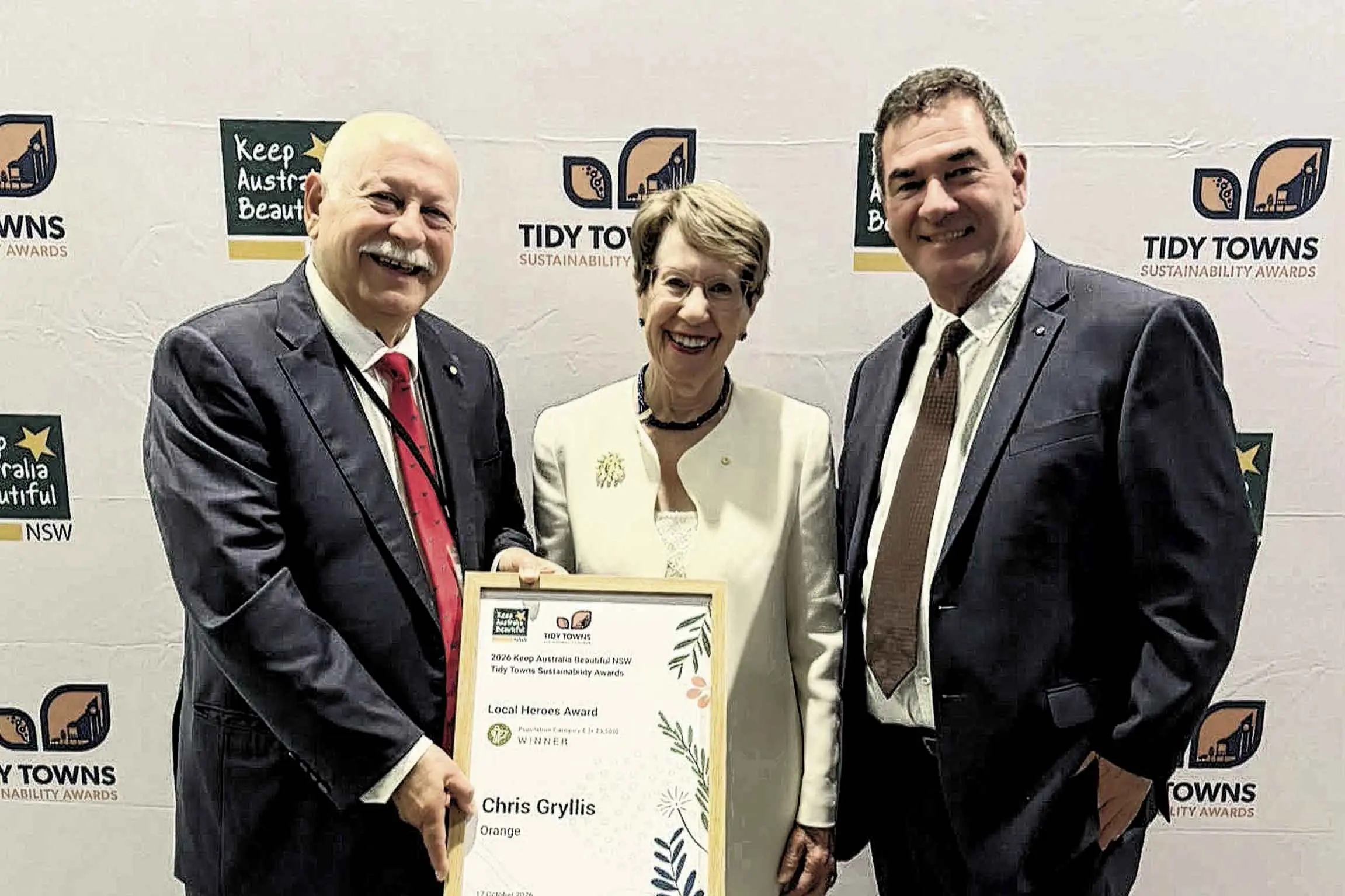 <p>2026 NSW Local Hero Award winner Chris Gryllis OAM with Her Excellency, the Honourable Margaret Beasley ACKC - Governor of NSW, and Orange Mayor Tony Mileto. Photo: courtesy of Cr Mileto.</p>\\n